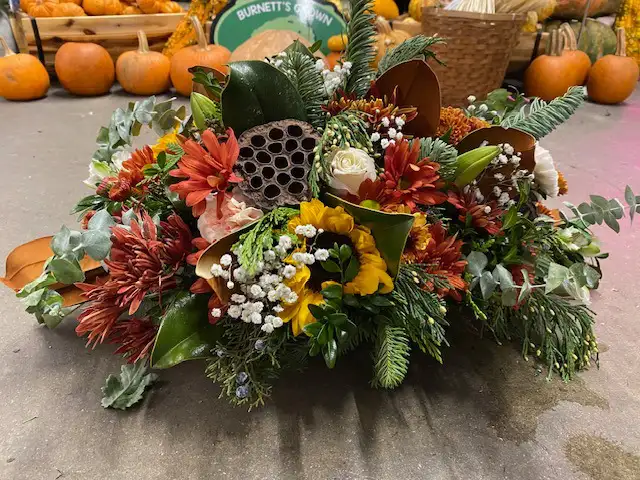 A beautiful Thanksgiving centerpiece featuring fall flowers and foliage 